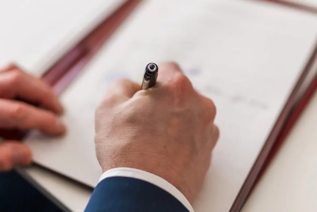 Mano firmando - Cuánto se demora una escritura en el registro