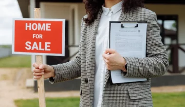 Mujer sosteniendo un cartel de "casa en venta" - captar propiedades para vender